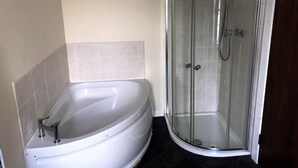 Ein Badezimmer mit einer freistehenden Badewanne und einer Duschkabine.