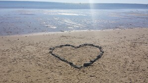 A beach with a heart-shaped outline drawn in the sand.