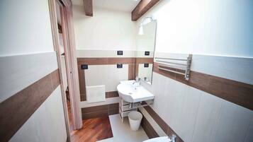 Un bagno compatto con vasca, lavandino e doccia.