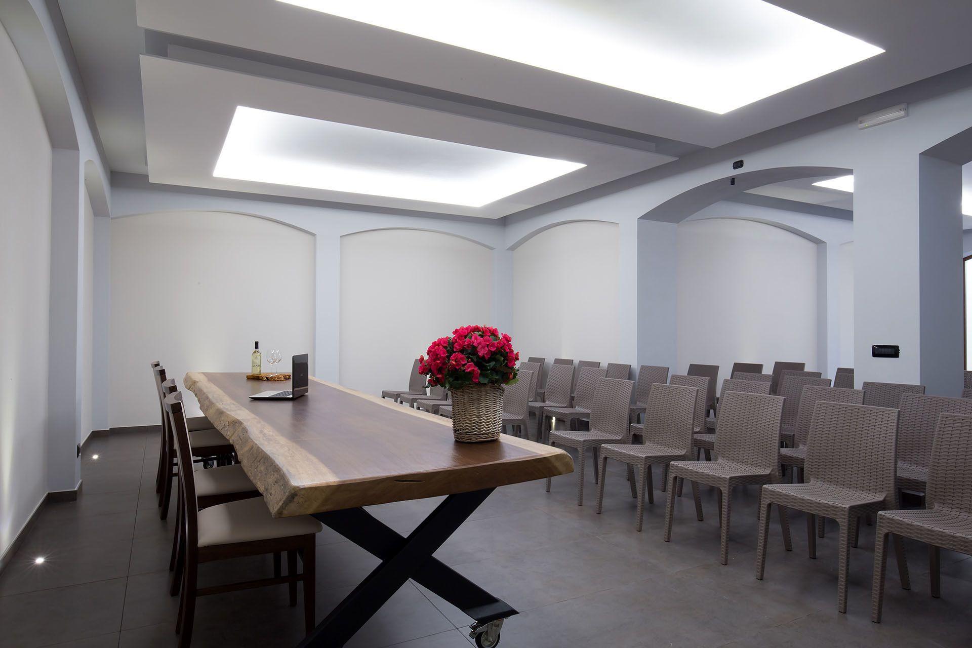 A conference room with a long table, chairs, and a ceiling with skylights.