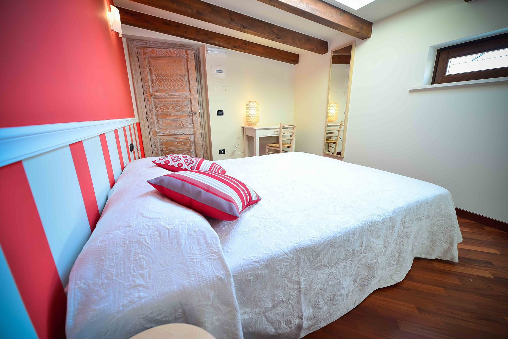 A bedroom with a bed, a desk, and a chair.