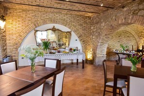 A restaurant with brick walls, arched ceilings, and a table set for dining. - Casale905 (Crecchio)