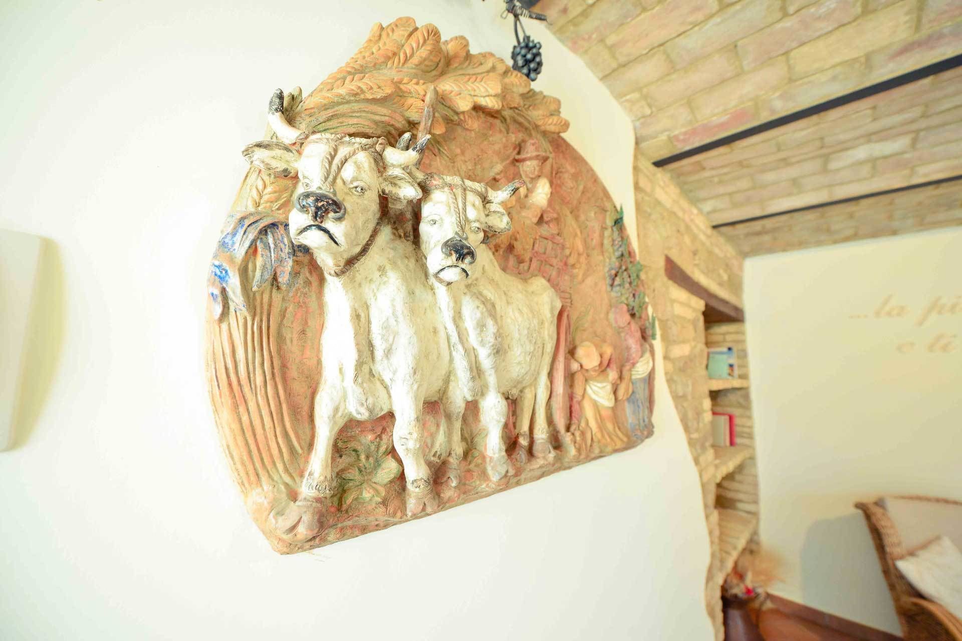 A wall-mounted decorative piece with a pastoral scene, including sheep and a cow.