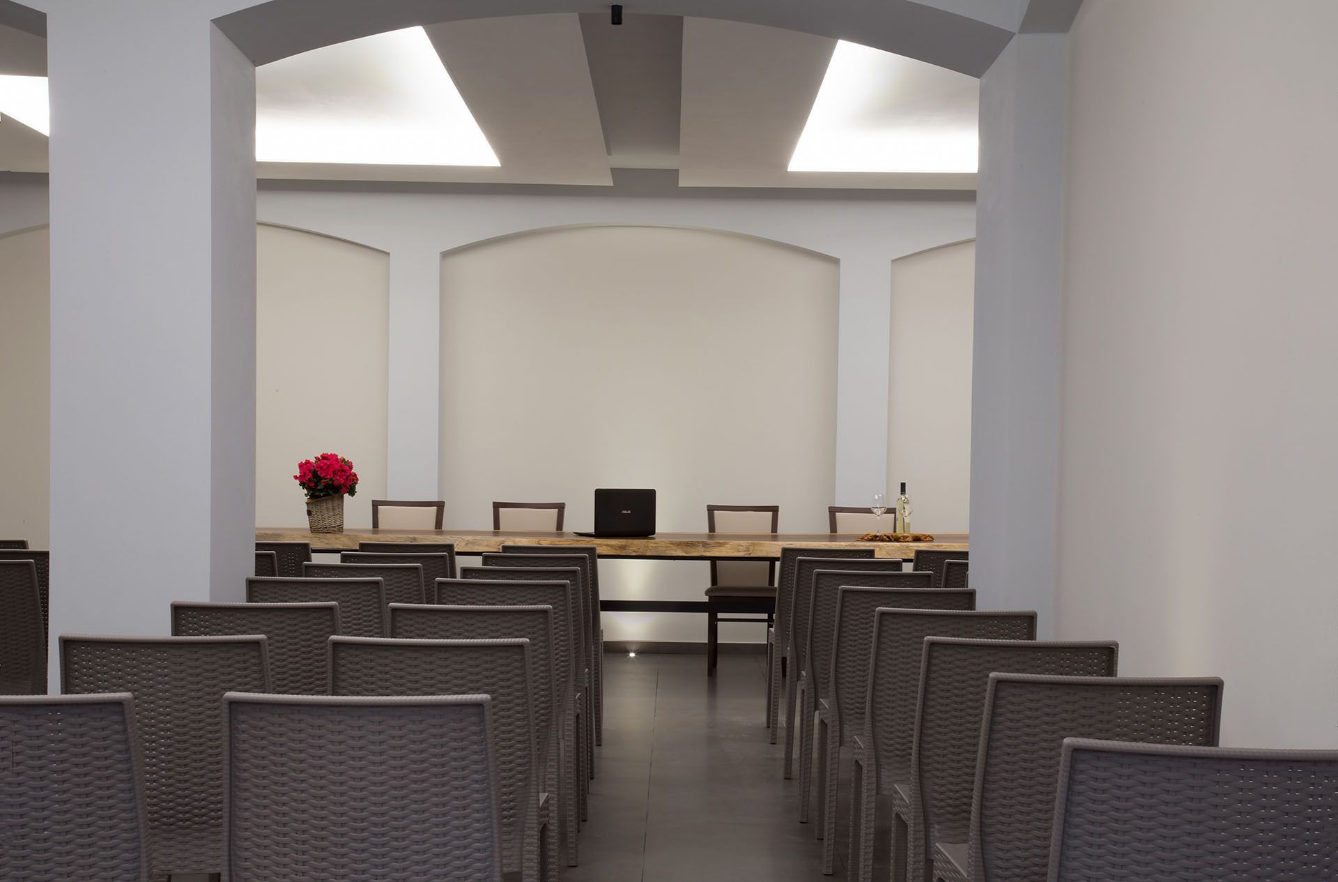 A conference room with a long table, chairs, and a laptop.
