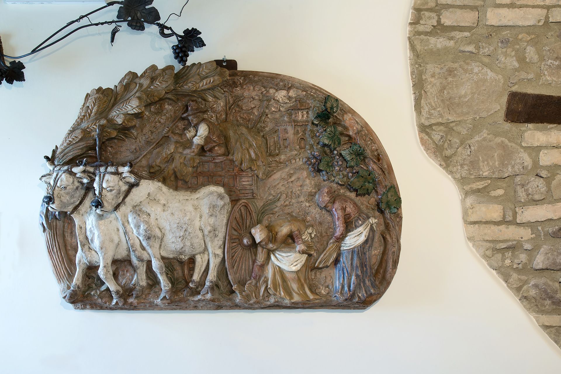 A wall-mounted sculpture depicting a pastoral scene with a man, a cow, and a dog.