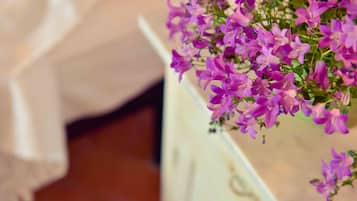 Primer plano de flores moradas en un jarrón blanco.