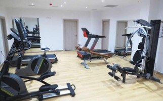 Ett gym med löpband, crosstrainers och utrustning för styrketräning.