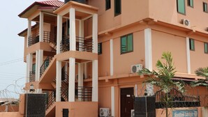A multi-story building with a central staircase, balconies, and a sign indicating "Nagino Lodge". - Nagino Lodge (Nyanyanu)