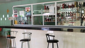 A bar area with three stools, a counter with bottles, and a glass display case. - Nagino Lodge (Nyanyanu)