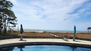 A clear swimming pool with a wooden deck, a wooden fence, and a view of the beach. - FALL RATES ! Discounted rates. Book with Affirm. New Beach! (Dauphin Island)