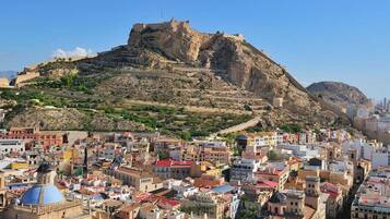 A cityscape with a prominent hill featuring a fortification.