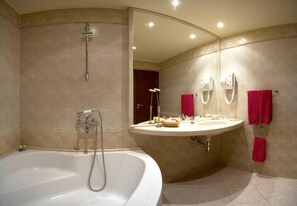 Une salle de bain avec une baignoire, un lavabo et un miroir.
