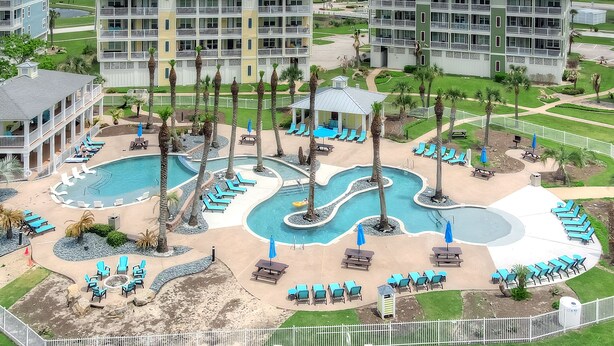 Ein Resort mit mehreren Pools, Liegebereichen und Blick aufs Meer.