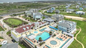 Ein Resort mit mehreren Gebäuden, einem Schwimmbad und einem Strandbereich.