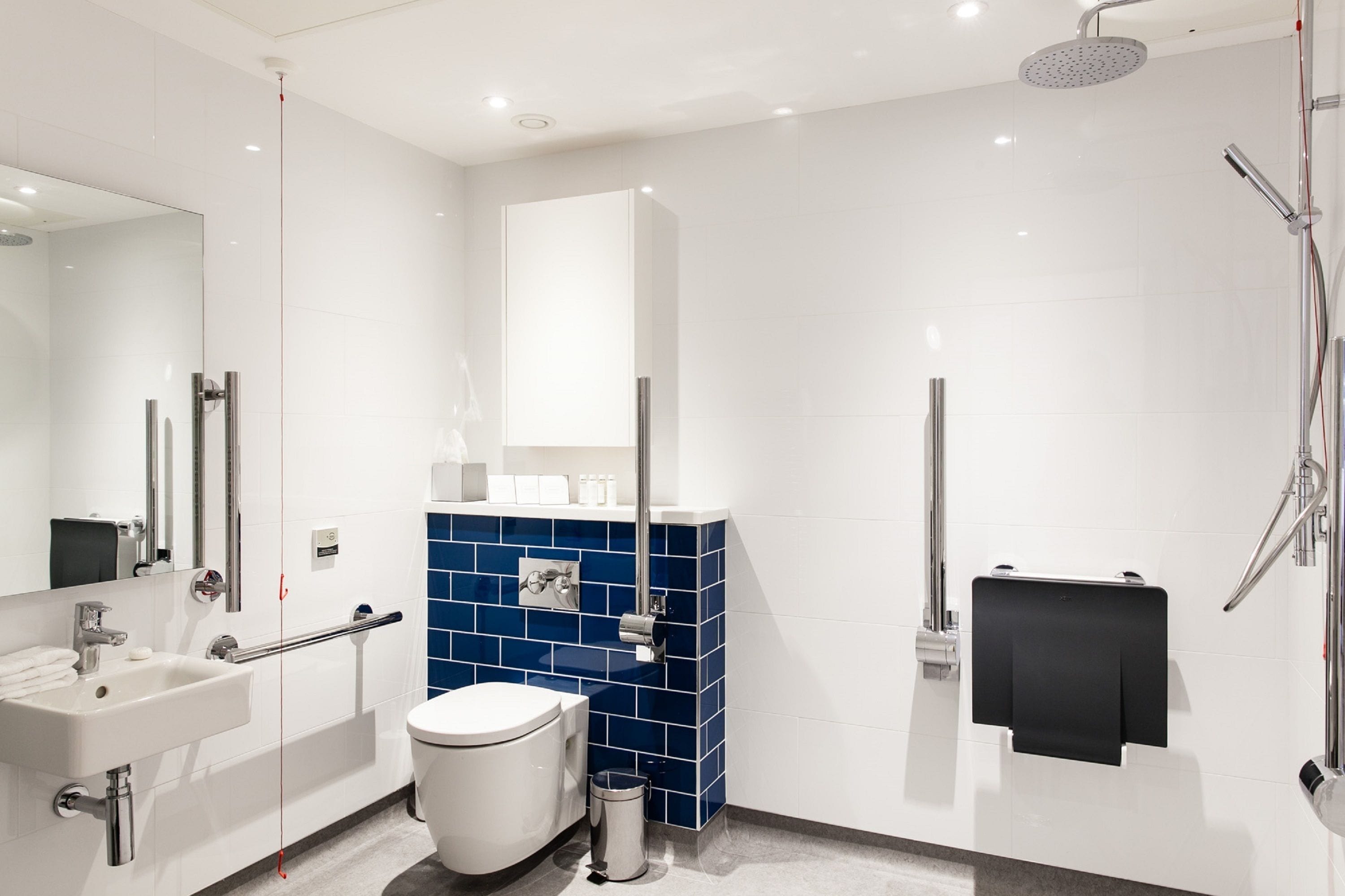 A modern bathroom with a white sink, toilet, and shower.
