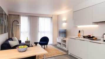 Una cocina moderna con comedor, televisor y una isla de cocina.