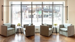 A modern room with a large window, two sofas, and two small tables.