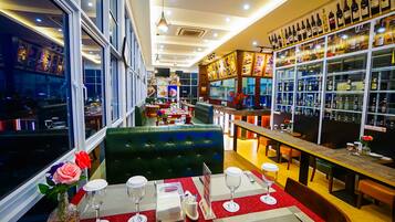 Un ristorante con zona bar, posti a sedere e vista sulla città attraverso ampie finestre.