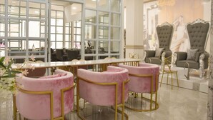 A luxurious hotel lobby with a large glass partition, elegant seating, and a grand sofa. - Green Rose Hotel (Batam)
