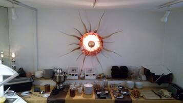 A buffet setup with a decorative wall piece, serving utensils, and various food items.