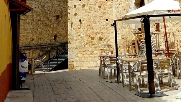 A courtyard with stone walls, outdoor seating, and a staircase leading to an upper level. - Hotel-Motel Sol II (Requena)