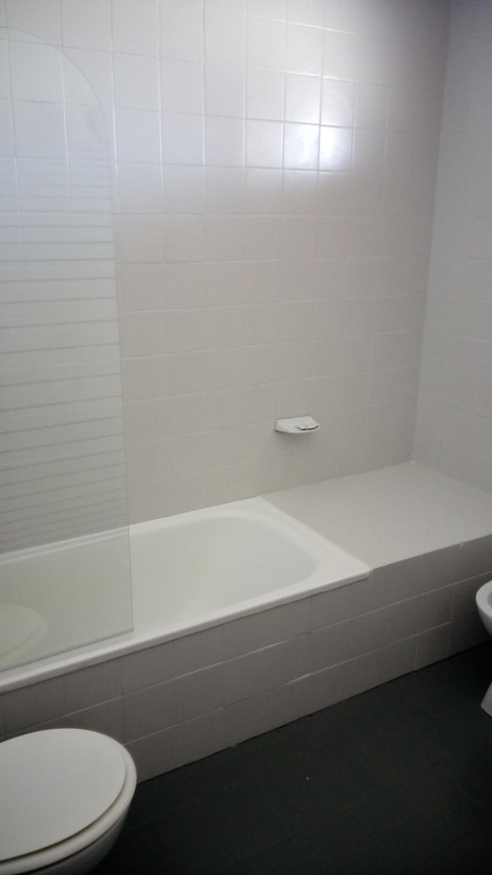 Une salle de bain équipée d’une baignoire, de toilettes et d’un sèche-mains.