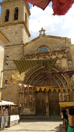 Un bâtiment historique doté d’un clocher, d’une façade richement décorée et d’une série de bannières.