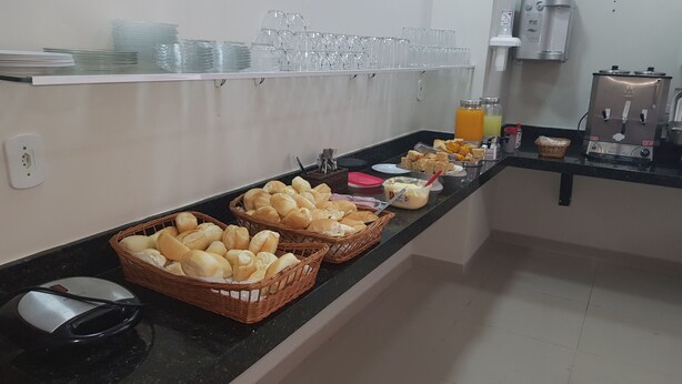 Un dispositiu de bufet amb cistes de pa, plats i dispensadors de suc.