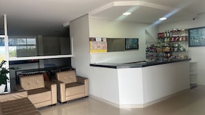 Una zona d'entrada moderna amb mostrador, seients i una presentació de petits refrigeris.