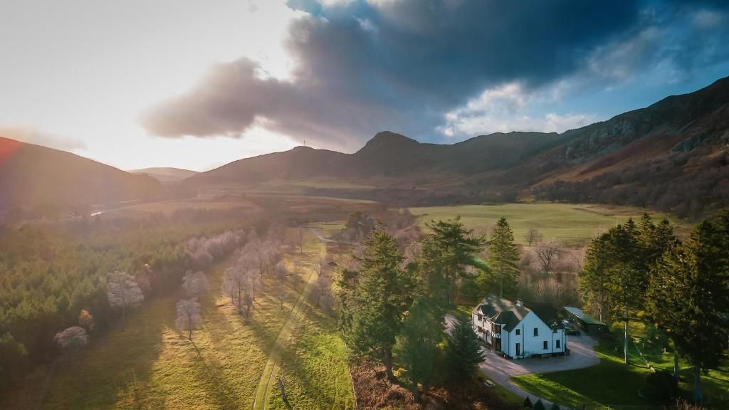 Ein weißes Haus mit Auffahrt und einem großen Feld im Vordergrund.