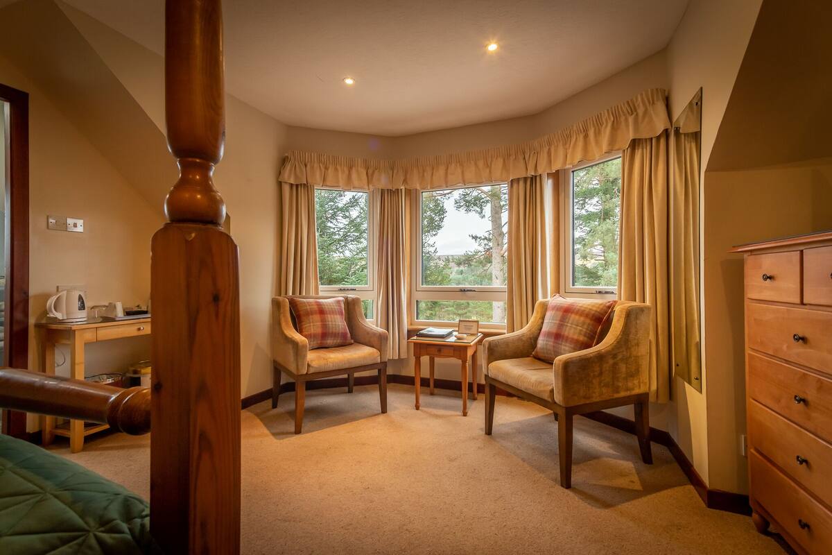 Une pièce chaleureuse avec deux fauteuils, une petite table et une commode en bois.