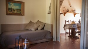 A cozy room with a sofa, two pillows, a table with a checkered tablecloth, and a painting on the wall. - Buccia Nera (Arezzo)