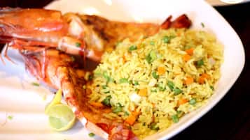 A plate of fried rice with vegetables and a large shrimp.