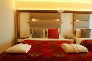 A hotel room with a large bed, two bedside tables, and a headboard with integrated lighting. - Green Suada Hotel (Pazar)