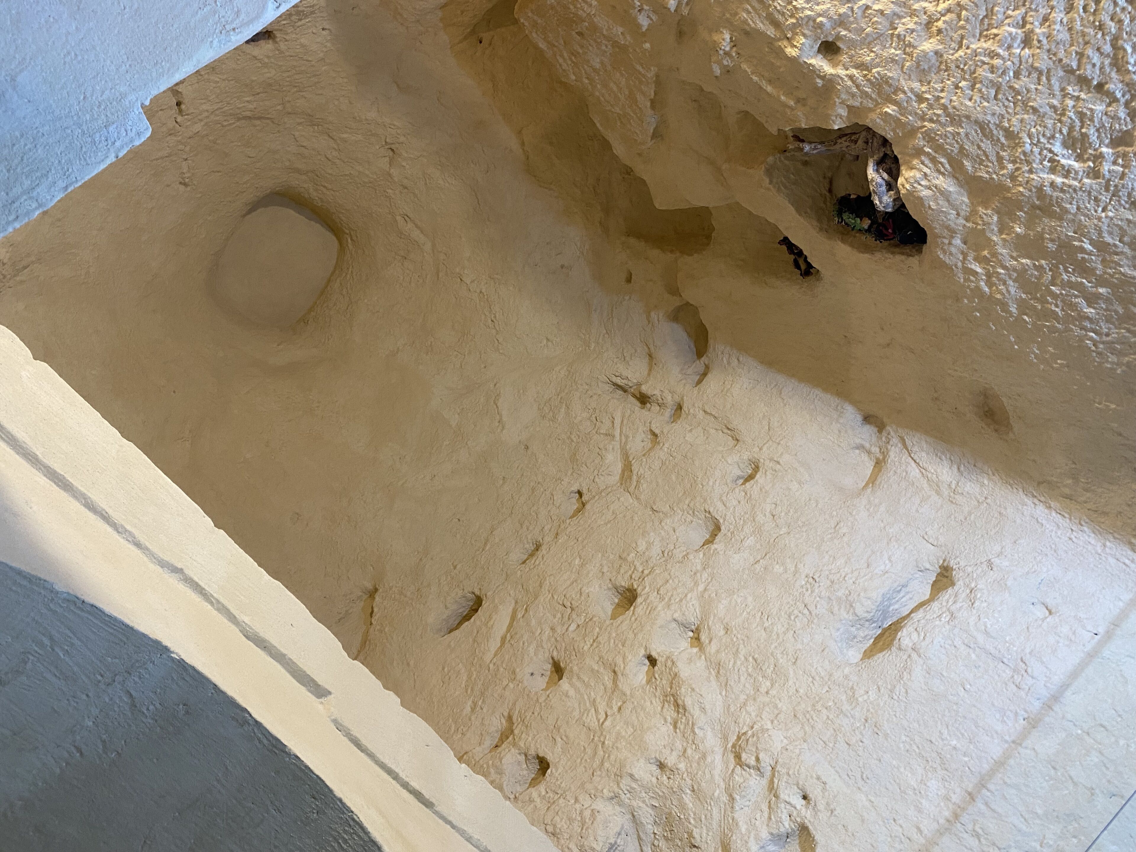 Een plafond met een structuur en een rond deukje.