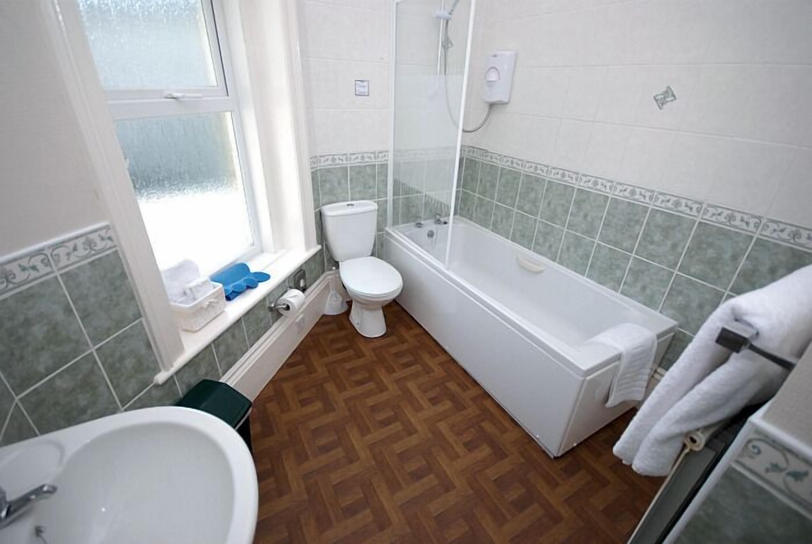 Kylpyhuone, jossa on pesuallas, wc ja kylpyamme.
