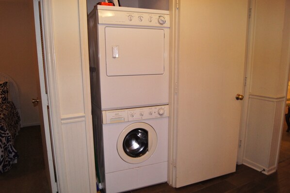 A compact, white, two-door laundry room with a front-loading washing machine and dryer. - Sea Cloisters 101d 3 Bedroom Condo by RedAwning (North Myrtle Beach)