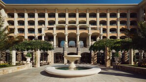 A hotel with multiple balconies, a central fountain, and outdoor seating areas. - Astor Garden Hotel (Varna)