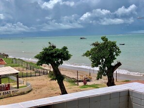 Une vue sur la plage avec un bâtiment, des arbres et une zone de plage.