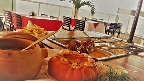 Une table de buffet avec divers plats et ustensiles.