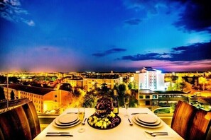 A table set for dining with a view of a cityscape at dusk. - Lozengrad Hotel (Kirklareli)