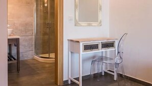Une salle de bain moderne avec une douche en verre, un meuble-lavabo blanc et un miroir.