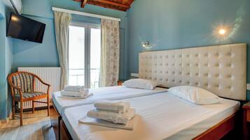 Habitación de hotel con dos camas, televisión y una silla.