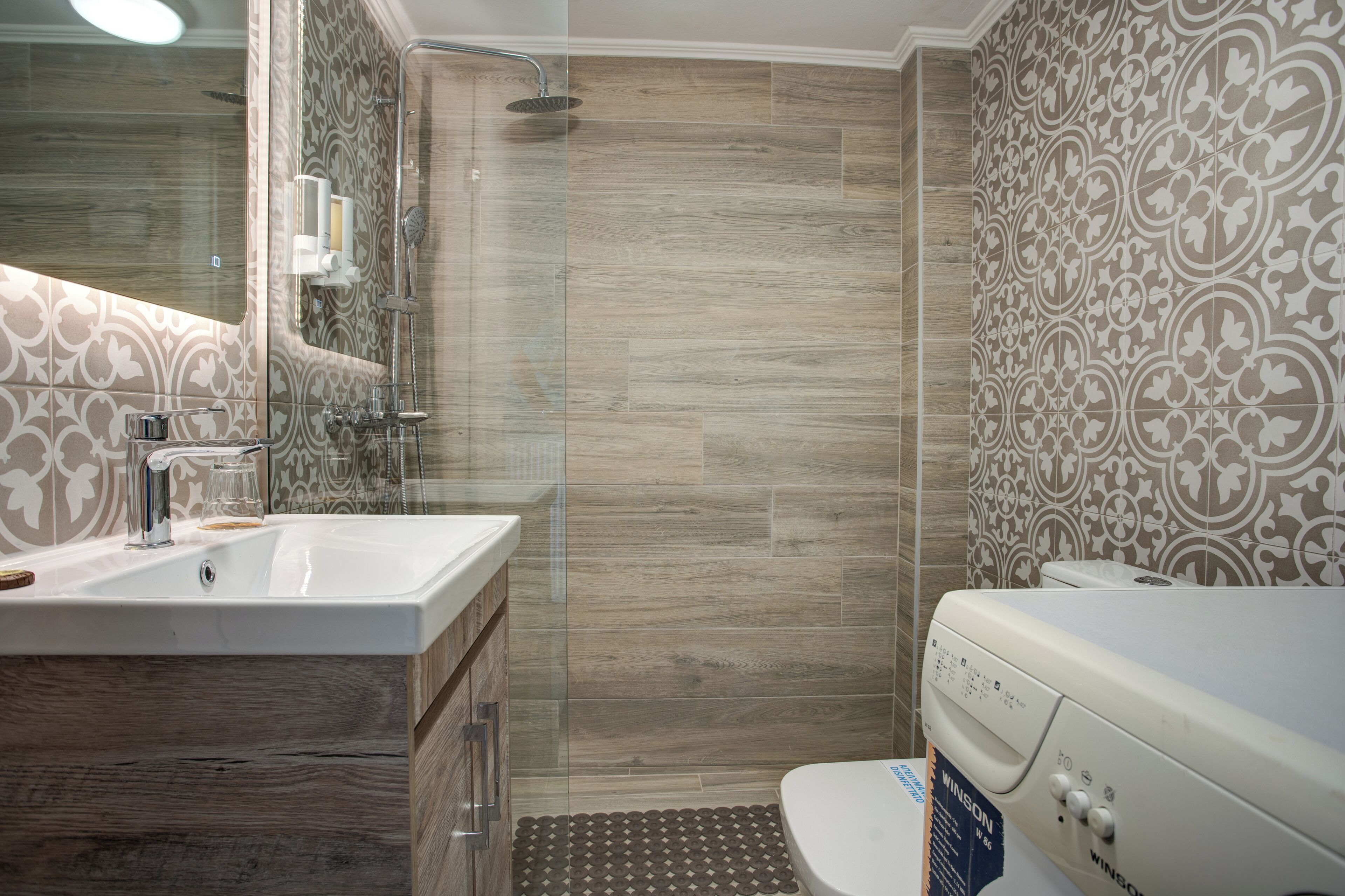 Un baño moderno con ducha, inodoro y lavamanos.