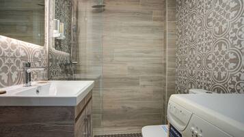 A modern bathroom with a shower, toilet, and sink.