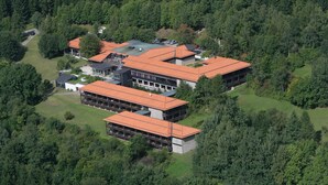 A large, modern building with multiple sections, surrounded by dense forest. - Berghotel Sankt Andreasberg (Braunlage)