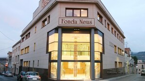 Un bâtiment d’angle, avec une enseigne indiquant « Fonda Neus » au-dessus de l’entrée.