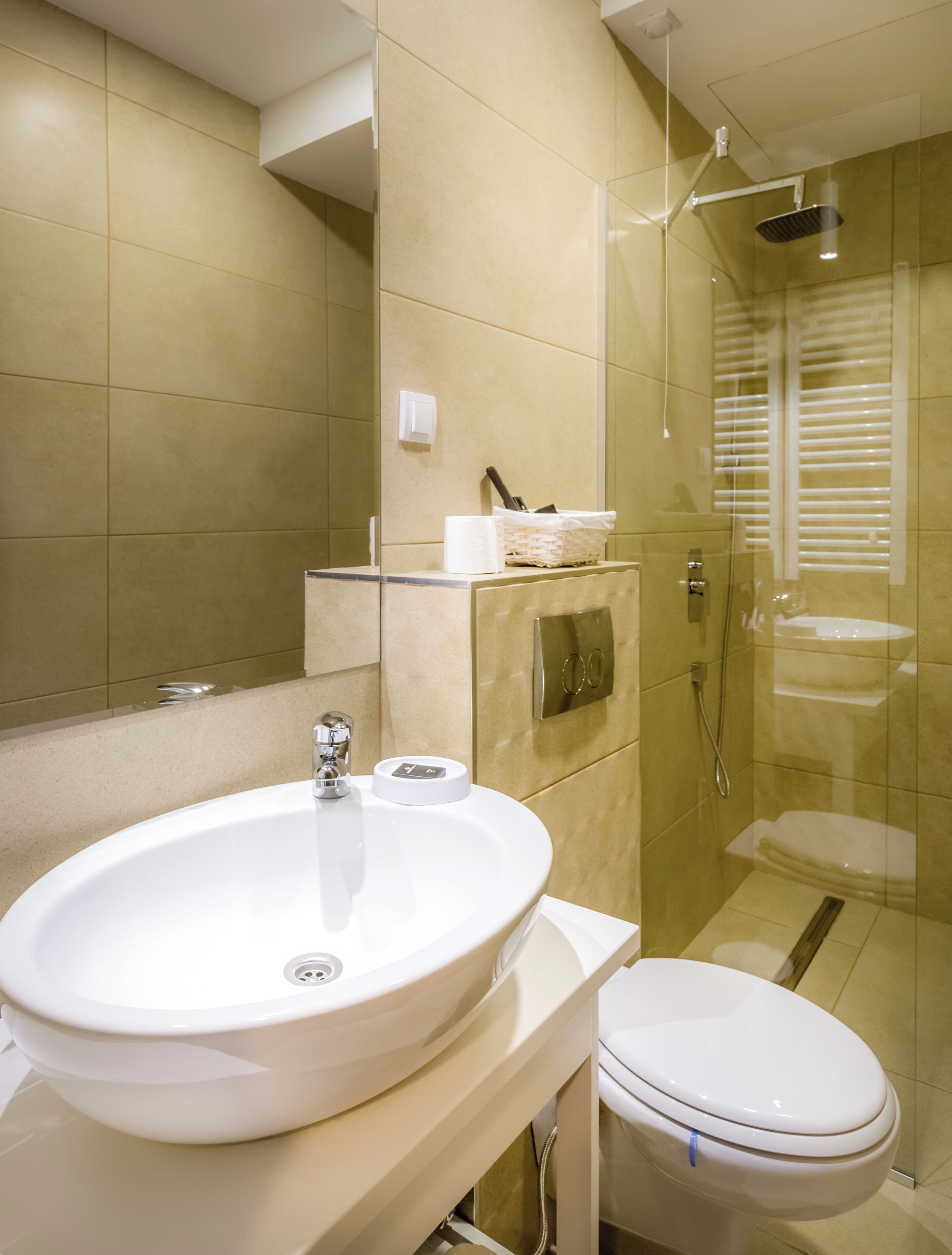 A modern bathroom with a large sink, toilet, and glass-enclosed shower.