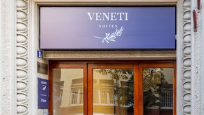 A hotel entrance with a sign reading "Venetti Suites" and a blue sign indicating the first floor. - Veneti Suites (Belgrade)