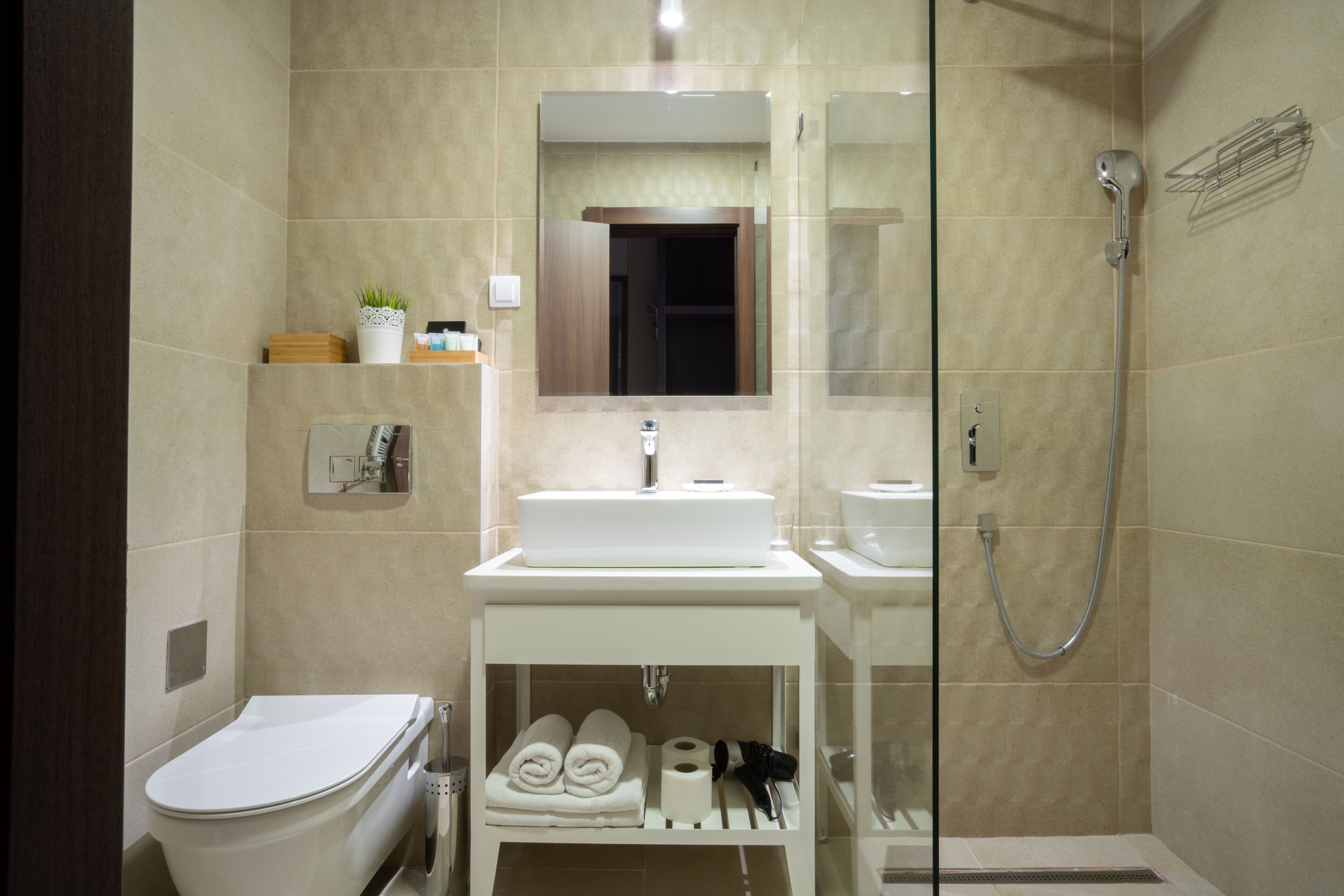 A modern bathroom with a toilet, sink, and shower.
